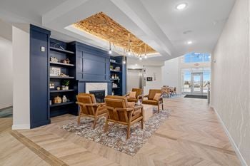 a living room with chairs and a fireplace